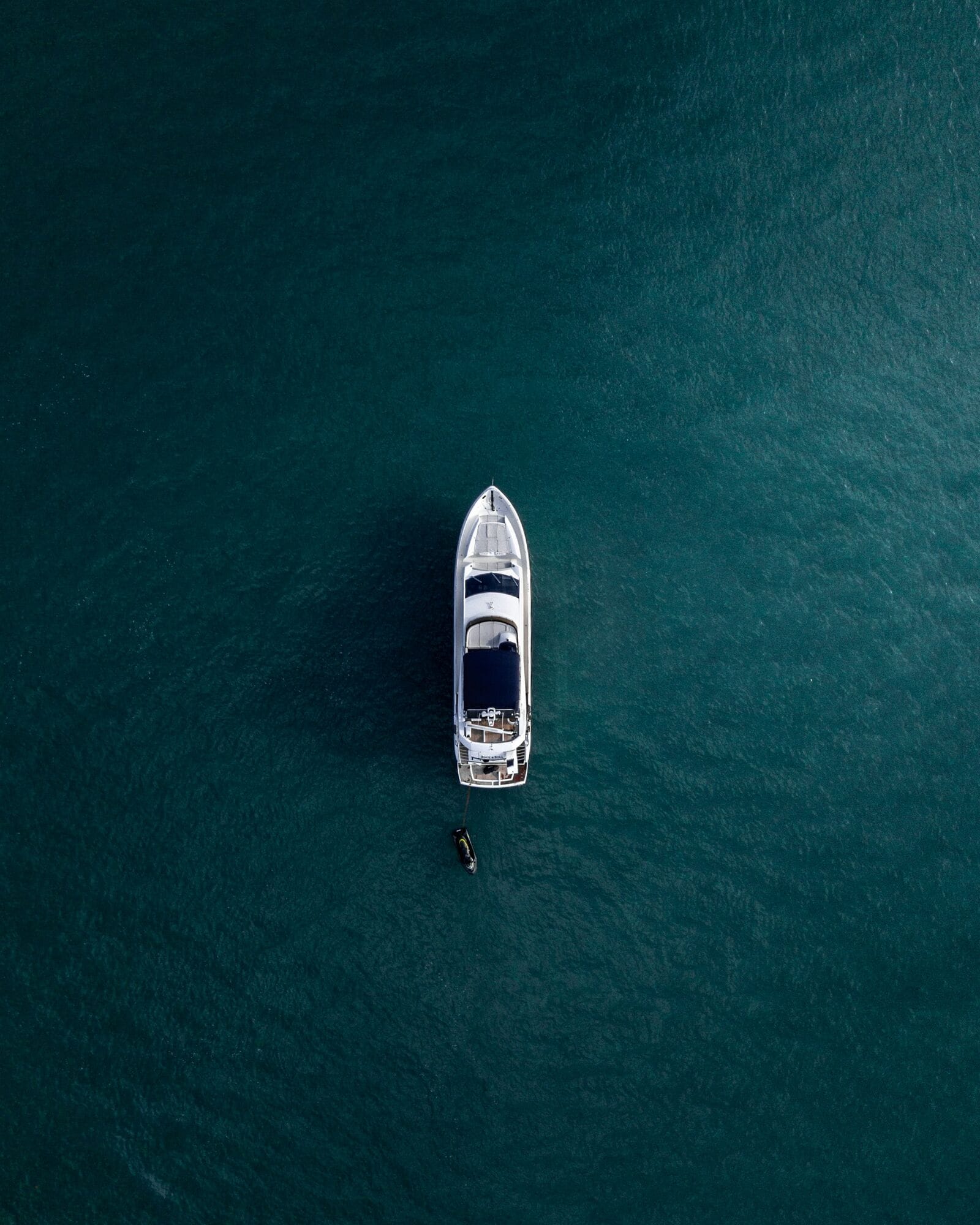 A yacht at anchor in clear water, seen from directly above at a swim stop